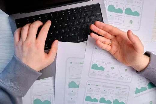 デザイン資料が広がる机での、UX/UI設計ワーク